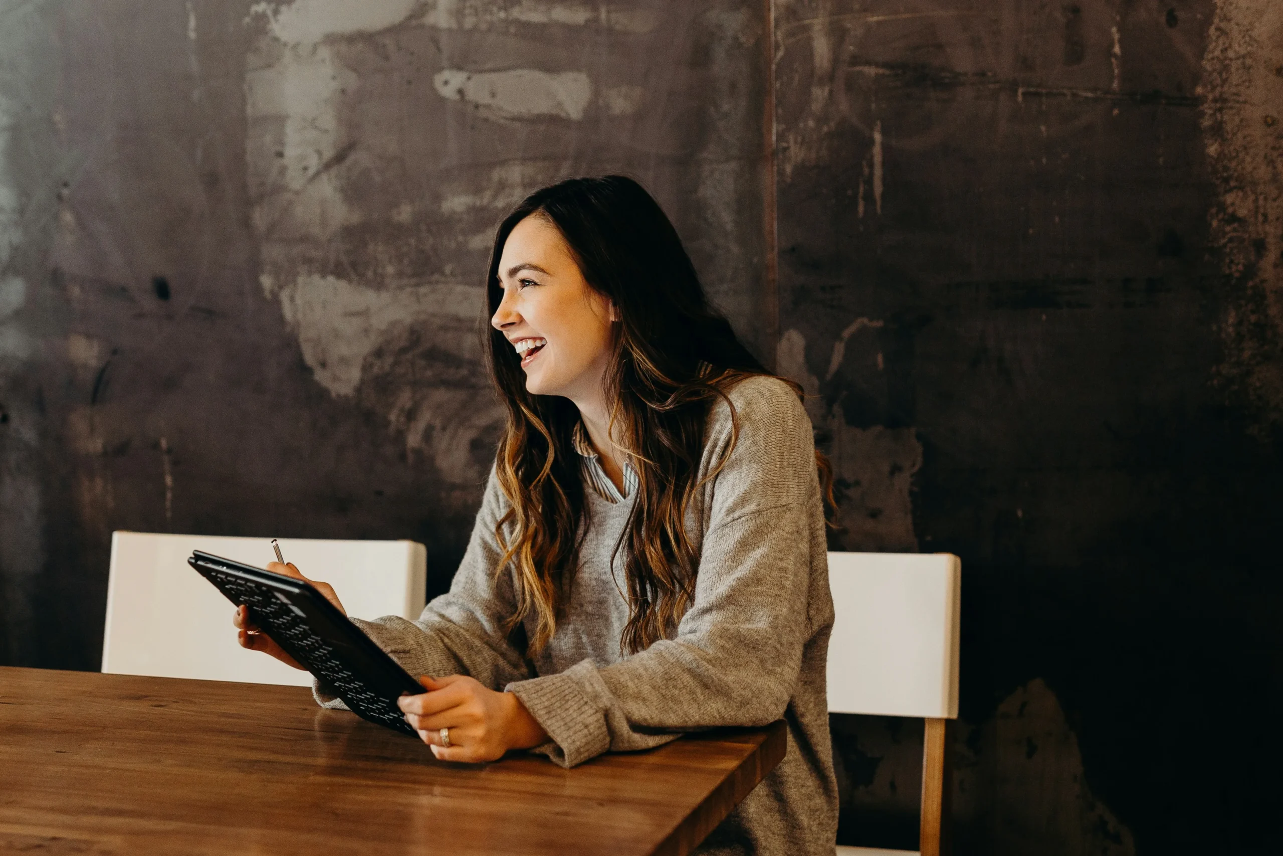 Girl sitting on table - looking to tablet