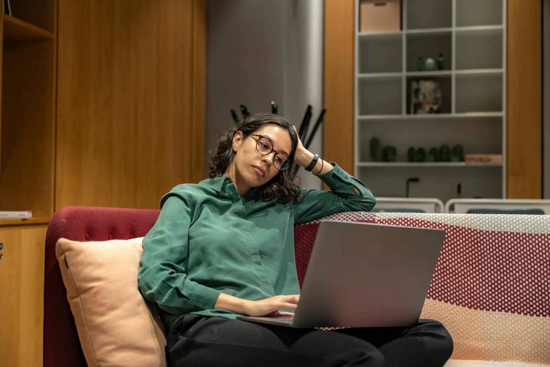 Girl sitting on sofa looking to laptop